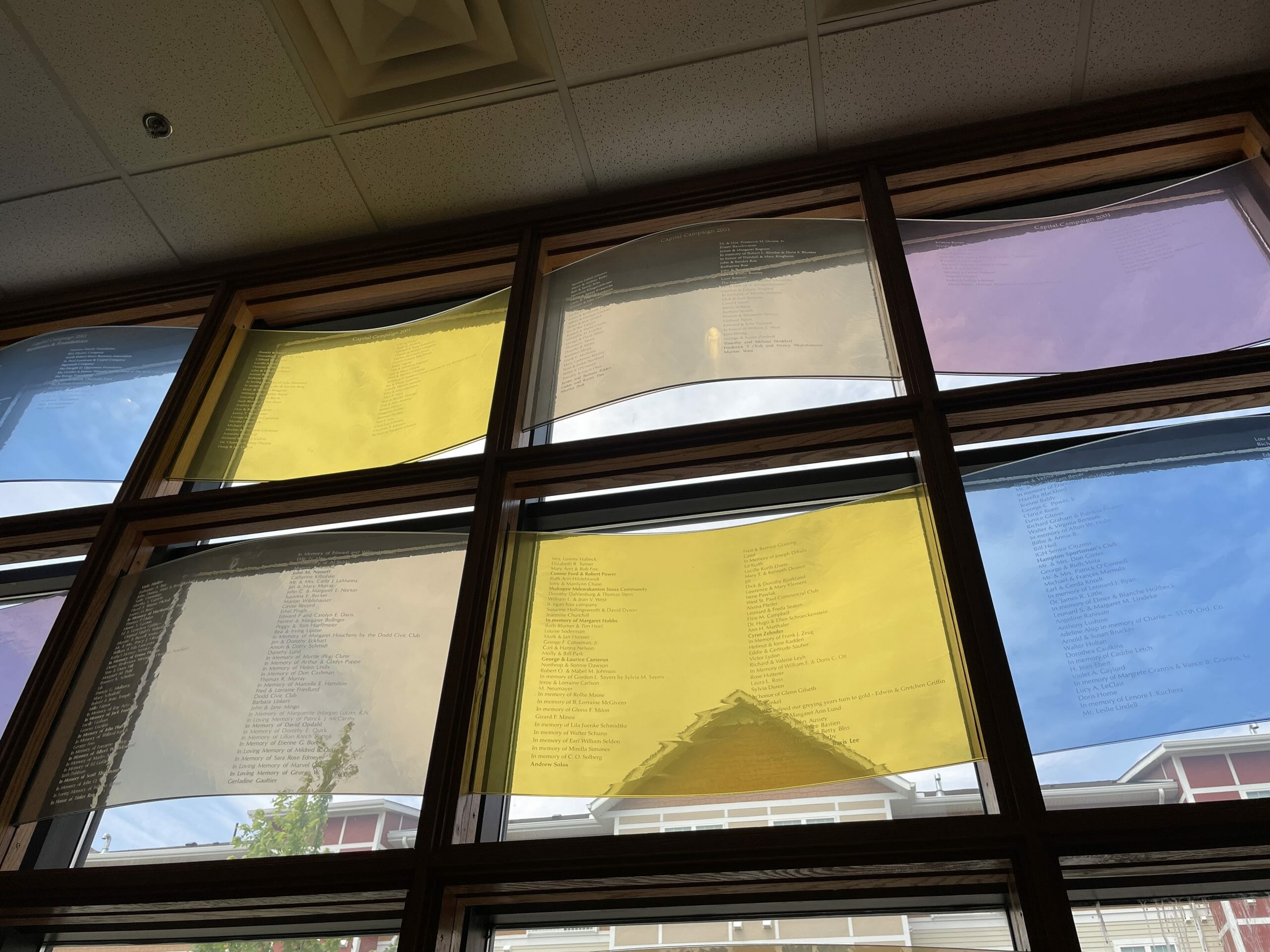 Windows in the Lindell Library showing the names of everyone in the DARTS Heritage Society who take joy in giving.