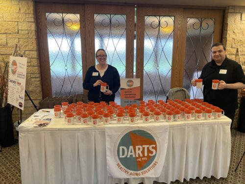 DARTS staff, Lindy and Vitali, show off DARTS new logo at the 10th Annual Fundraising Breakfast.